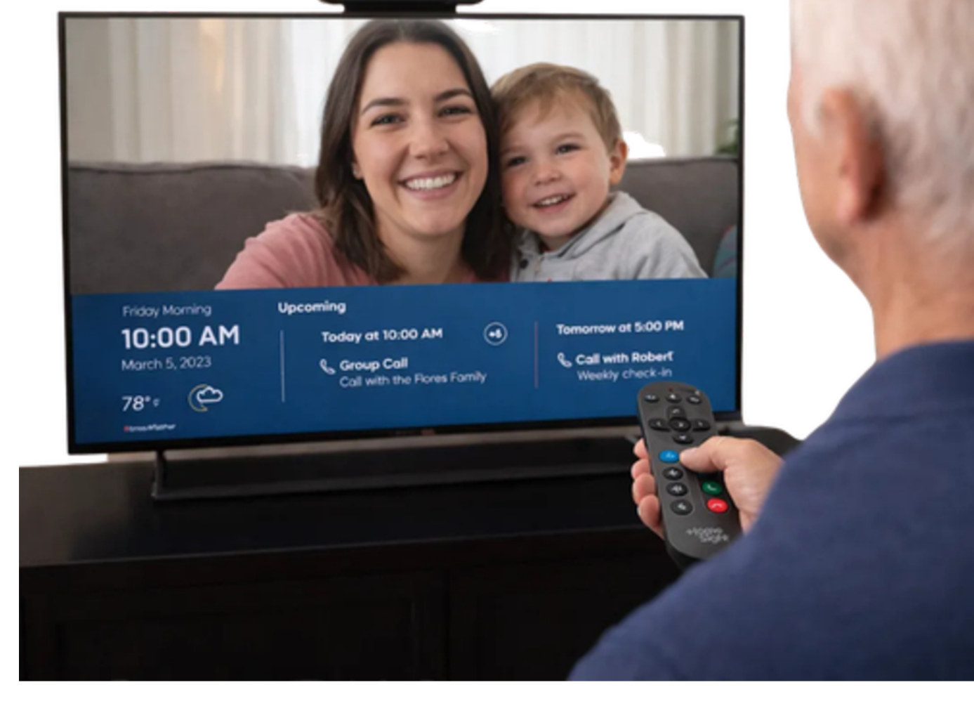 A senior on a family video call shown on their TV through HomeTogether, holding the simple remote